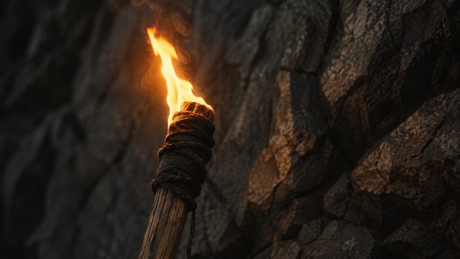 Brennende Fackel vor dunkler Felswand – Symbolbild der Kenaz-Rune (Fackel, Erkenntnis)